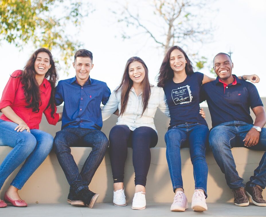 group of people sitting on bench near trees duting daytime